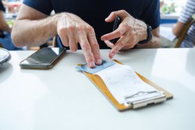 A person paying the bill with their credit card. 