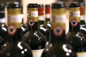 the tops of red wine bottles with gold wrappers, DOCG, and a black rooster emblem indicating Chianti Classico