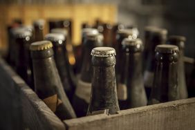 Old dusty bottles of beer in a wooden case.