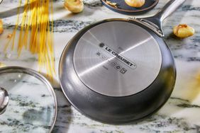 Inverted Le Creuset Toughened Nonstick Pro frying pan displayed with a lid on a marble surface