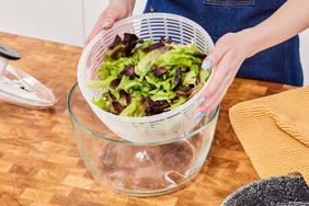 A person removing the inner basket from the OXO Glass Salad Spinner