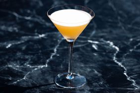 French Blonde cocktail in a Martini glass against a dark, slate marble background