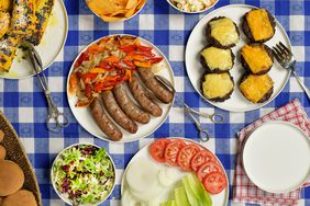 Summertime BBQ with bratwurst, burgers, cheese, corn, potato chips, salad, peppers, onions, tomatoes