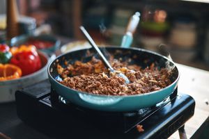 Ground beef being cooked in a blue pan. 