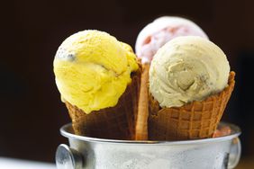 Three cones of different flavored ice cream.