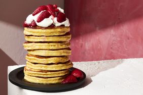 a stack of Masa Pancakes with strawberries and whipped cream on top