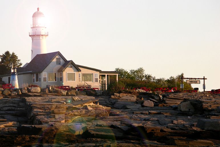 The Lobster Shack at Two Lights seen at sunrise with lighthouse in background.