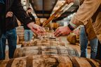 A copper whiskey thief being used to sample whiskey from Nashville Barrel Company