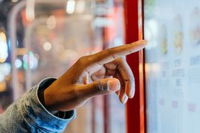 A person ordering from an electronic touch screen.