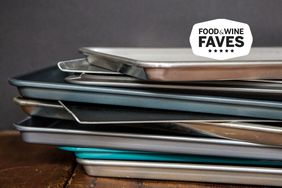 Several cookie sheets stacked on a wood table