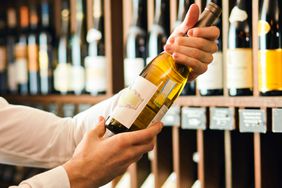 A person checks out a bottle of wine in a store