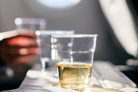 A person enjoys a white wine on a flight